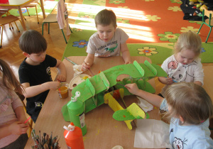 Dzieci malują model samolotu.