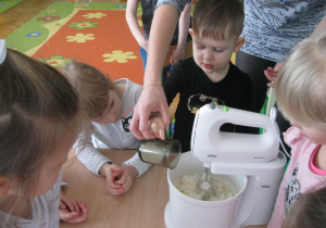 Dzieci wrzucają składniki do miksera.