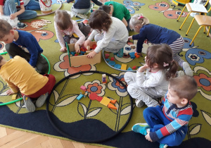Dzieci łączą różne drewniane klocki.