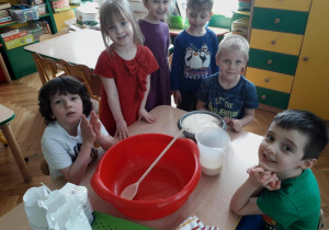 Dzieci przygotowują składniki do wyrobu ciasta drożdżowego.