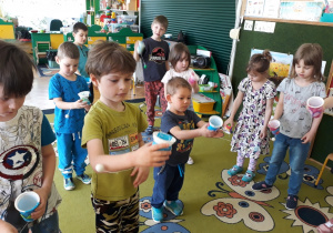 Dzieci wypróbowują zabawkę zręcznościową wykonaną z kubka.