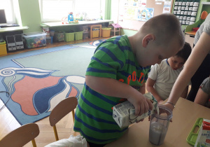 Chłopiec wlewa mleko do blendera.