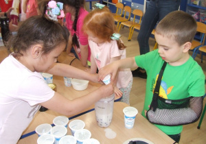 Dzieci dolewają jogurty do blendera.