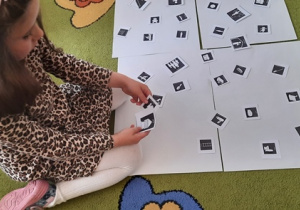 Dziewczynka układa z piktogramów historyjkę.