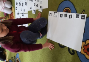 Dziewczynka układa z piktogramów historyjkę.