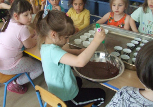 Dziewczynka miesza składniki ciasta.