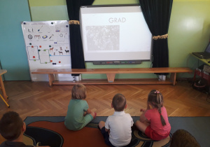 Dzieci oglądają prezentację o zjawiskach atmosferycznych.
