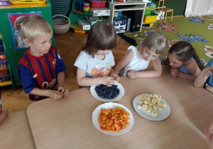 Dzieci smakują owoce.