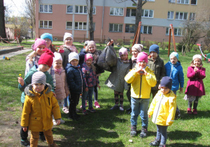 Dzieci prezentują zebrane śmieci z ogródka.