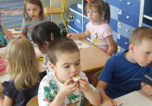 Dzieci jedzą przygotowane przez siebie babeczki.