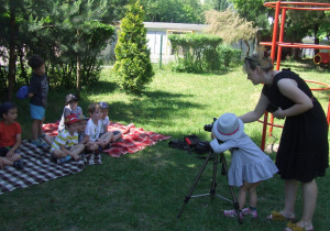 Dziewczynka robi zdjęcia grupie dzieci.