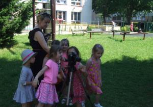 Dzieci oglądają zrobione zdjęcia w aparacie.