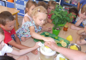 Dzieci wyciskają cytrynę.