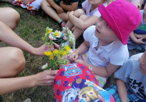 Dzieci oglądają polne kwiaty.