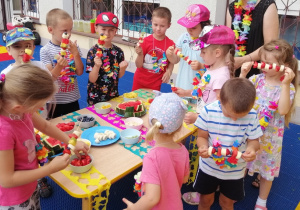 Dzieci przygotowują owocowe szaszłyki.