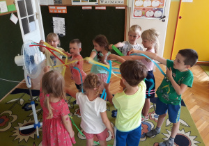 Dzieci bawią się wstążkami z bibuły.