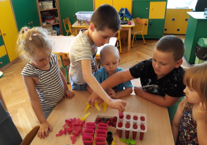 Dzieci zamykają pojemniczki do wyrobu sorbetów owocowych.