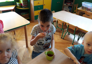 Dzieci jedzą mus truskawkowy z dodatkiem malin.
