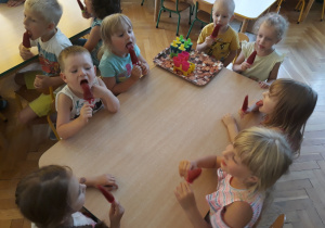 Dzieci jedzą lody na patyku - sorbet