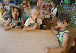 Dzieci jedzą lody na patyku - sorbet