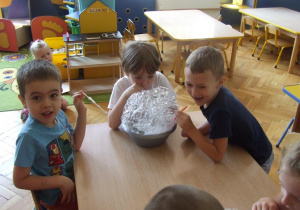 Dzieci tworzą bańki mydlane.