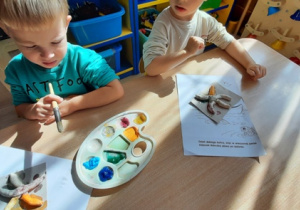 Chłopcy malują farbami rozgwiazdy wykonane z masy solnej