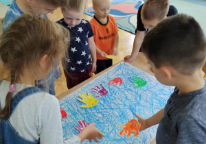 Dzieci naklejają rybki na namalowanym morzu