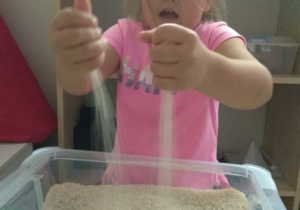 Dziewczynka przesypuje ryż.