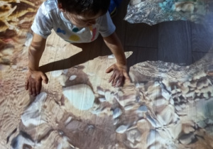 Dziecko bawi się na podłodze interaktywnej.