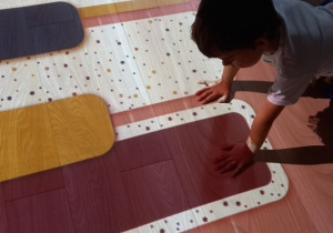 Dziecko bawi się na podłodze interaktywnej.