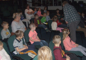 Dzieci przedstawiają się siedząc na widowni teatru.