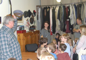 Dyrektor teatru oprowadza dzieci po garderobie.