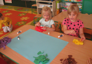 Dzieci przedzierają papier na drobne kawałki.