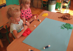Dzieci przedzierają papier na drobne kawałki.