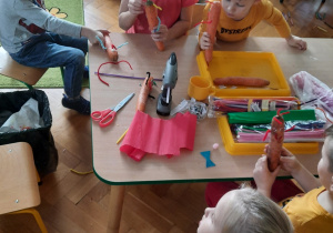 Dzieci wykonują kukiełki z marchewki.