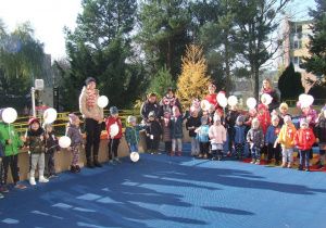Dzieci stoją z flagami na tarasie.