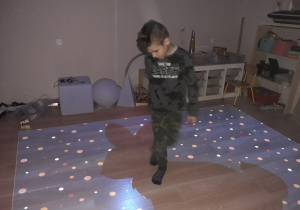 Chłopiec gra w grę na podłodze interaktywnej.