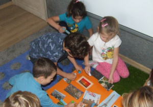 Dzieci przyklejają elementy do wielkiej europejskiej pocztówki.
