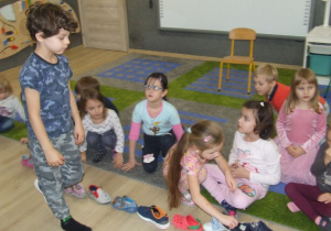 Dzieci układają buty jeden za drugim.