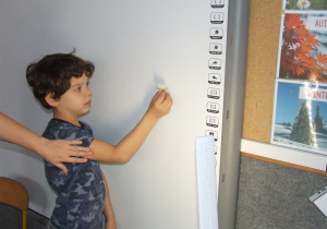 Chłopiec pokazuje cień kształtu z wosku.