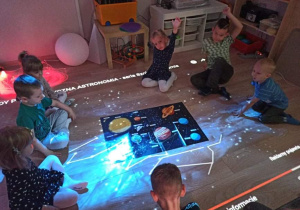 Dzieci w Sali Snoezelen oglądają kosmos.