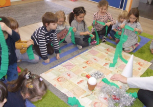 Dzieci oglądają materiały niezbędne do wykonania choinki.