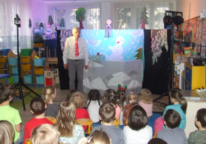 Aktor opowiada dzieciom o wizycie Mikołaja.