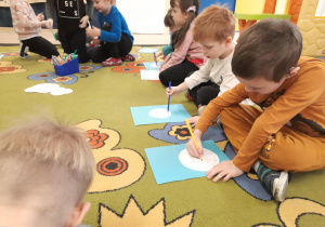 Dzieci rysują pisakami po swojej kartce.