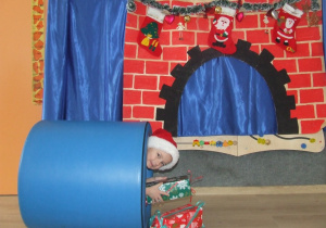 Chłopiec w stroju Mikołaja wychodzi z tunelu.