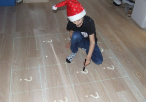 Chłopiec rysuje na podłodze interaktywnej.