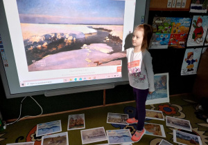 Dziewczynka ogląda pejzaż zimowy, na tablicy multimedialnej.