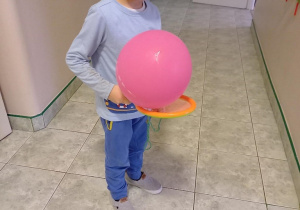 Chłopiec podrzuca balona.