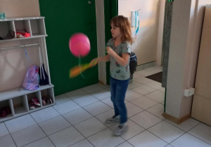 Dziewczynka podrzuca balona.