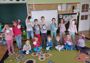Dzieci prezentują wykonane gwiazdki śniegowe.